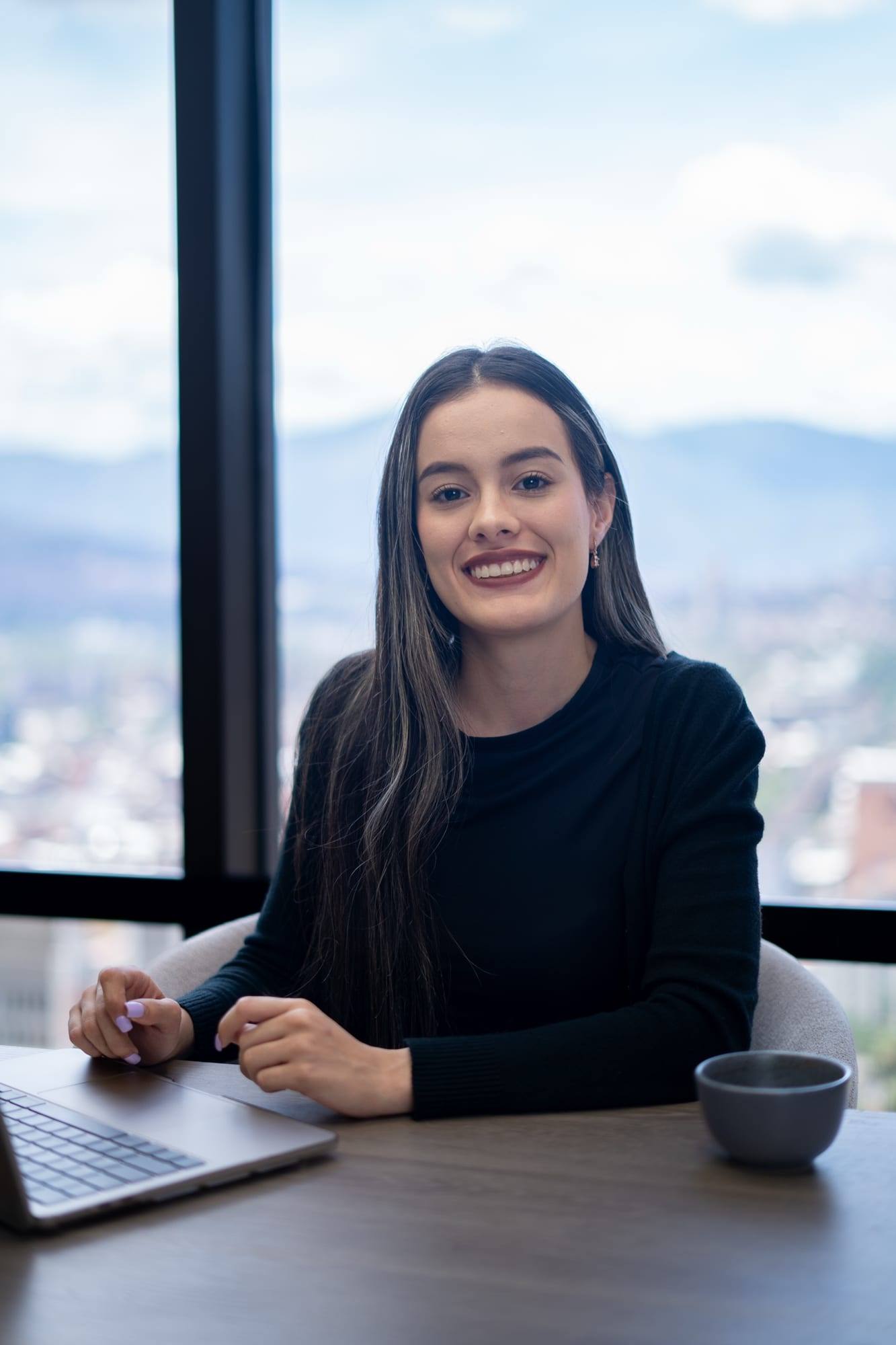 Integrante del equipo de Solvé Abogados sonriendo junto al ventanal de la oficina