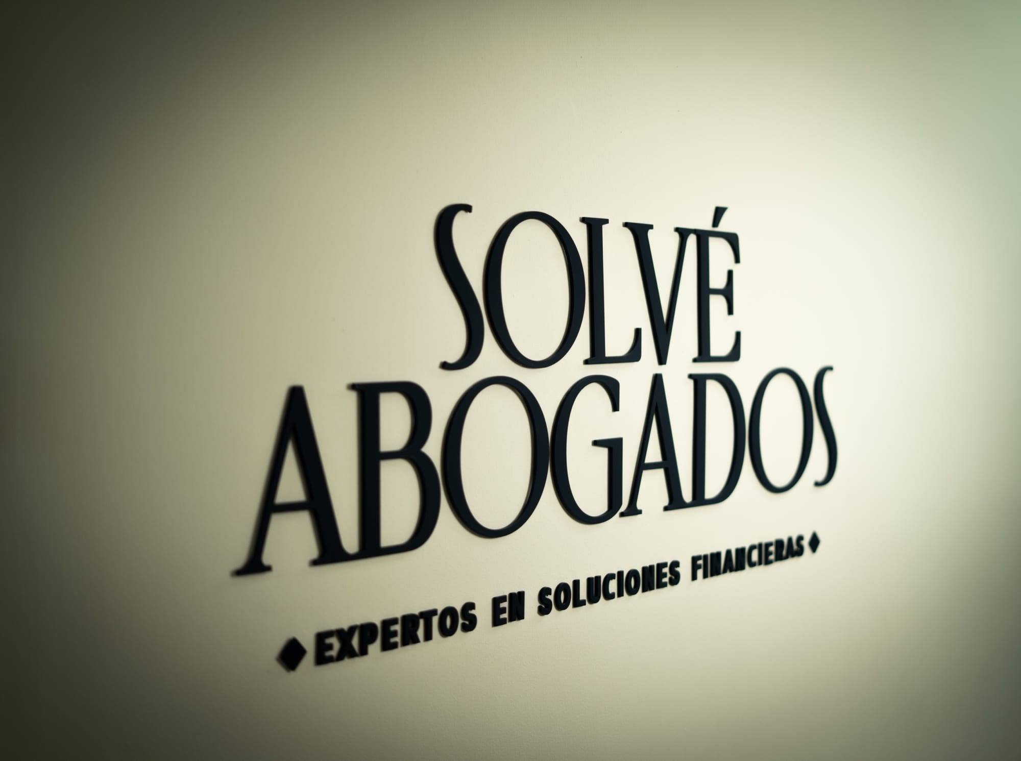 Letrero de Solvé Abogados en la recepción: «Expertos en soluciones financieras»